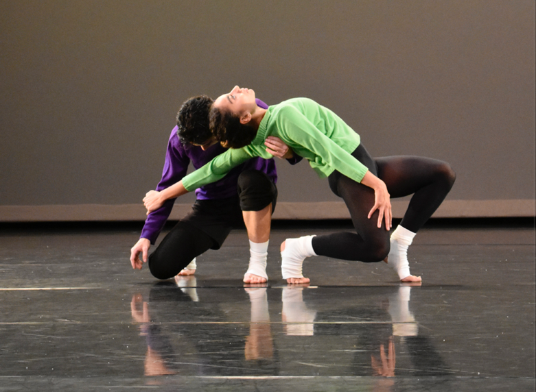 A person and person dancing on a stage

Description automatically generated